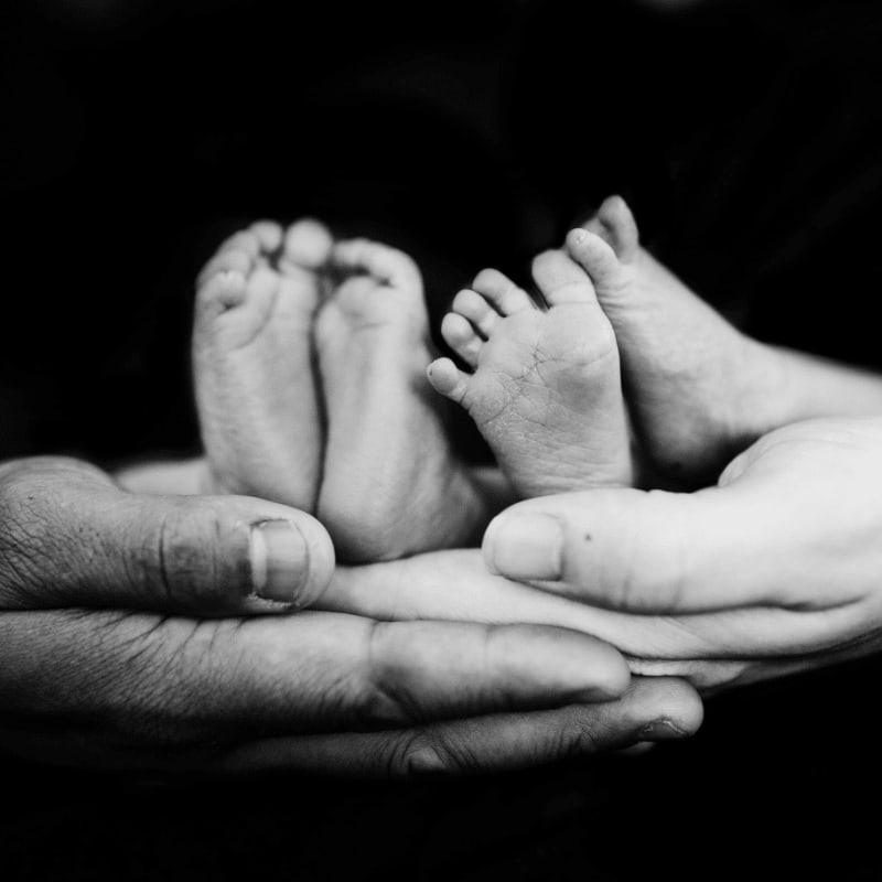 grayscale photo of person holding baby