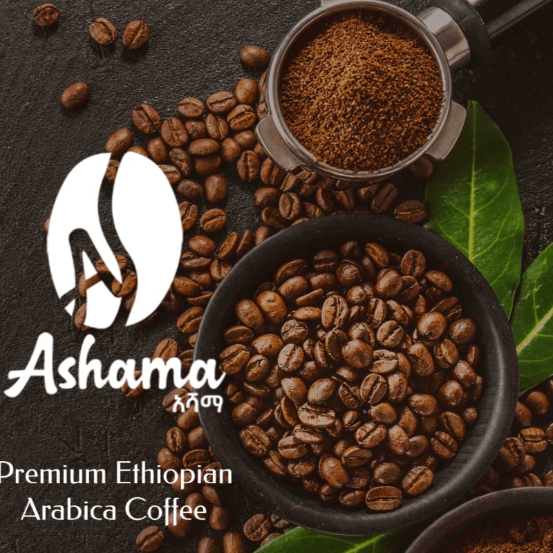 Roasted coffee beans fill a dark bowl in the foreground, with a portafilter of ground coffee and green leaves scattered around, all set against a dark, textured background.