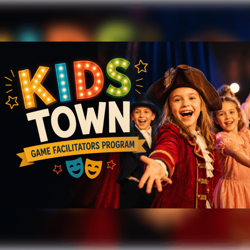 A group of smiling children in costumes, including a girl in a pirate outfit, are on a stage with the "KIDS TOWN GAME FACILITATORS PROGRAM" logo in the background.