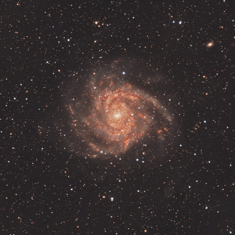A vibrant spiral galaxy with glowing arms dominates the dark, star-filled background.
