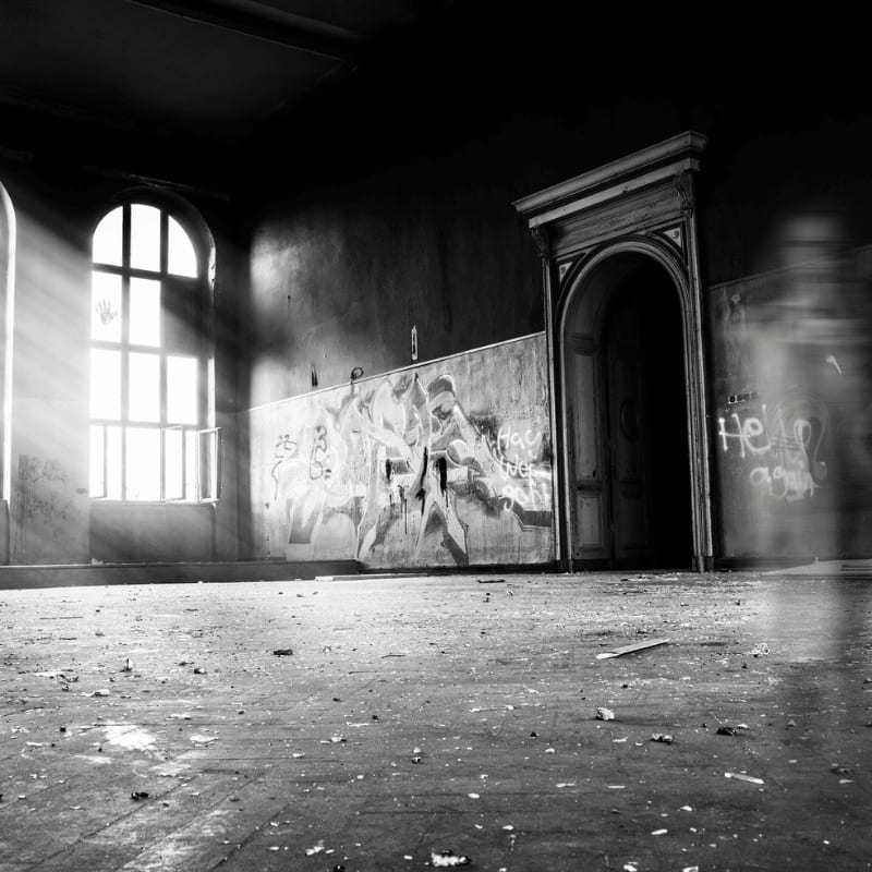 grayscale photo of person standing inside building