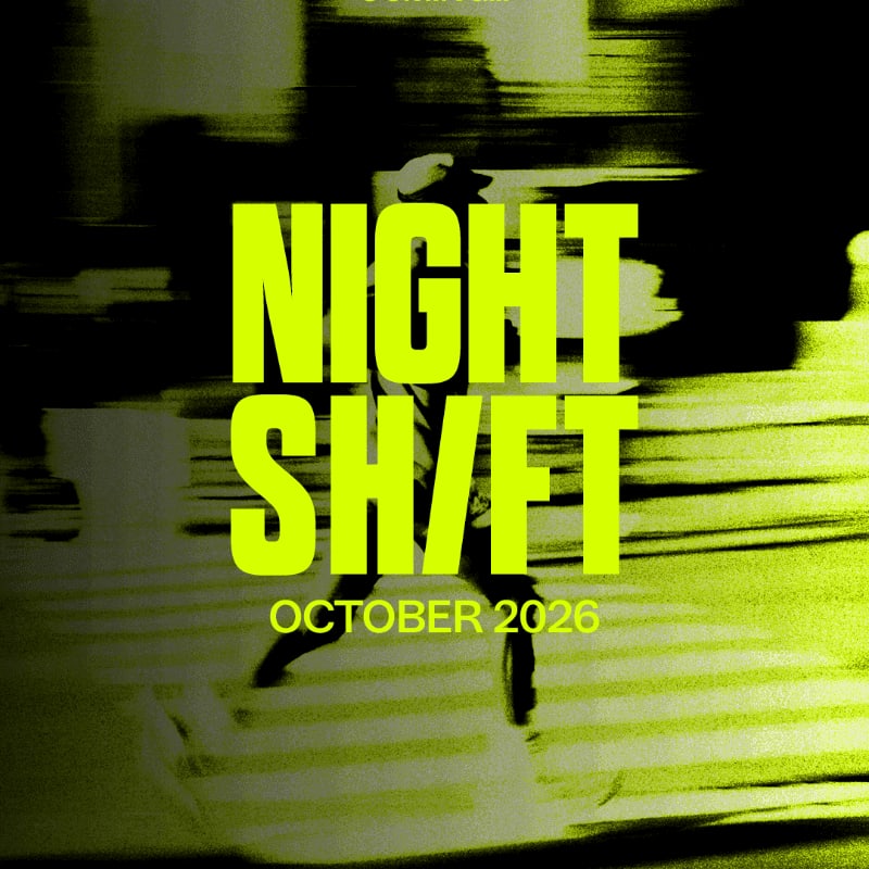 A person in silhouette crosses a street at night, with neon green text overlaying the scene.