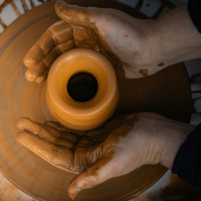 Potter shaping clay on a spinning wheel