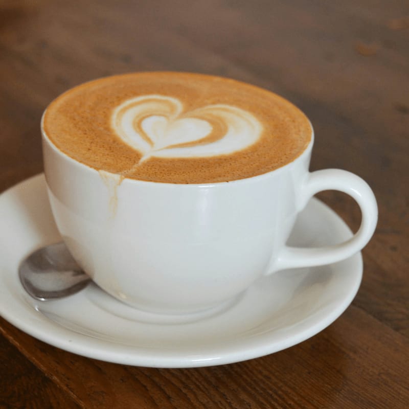 a cappuccino on a saucer with a spoon