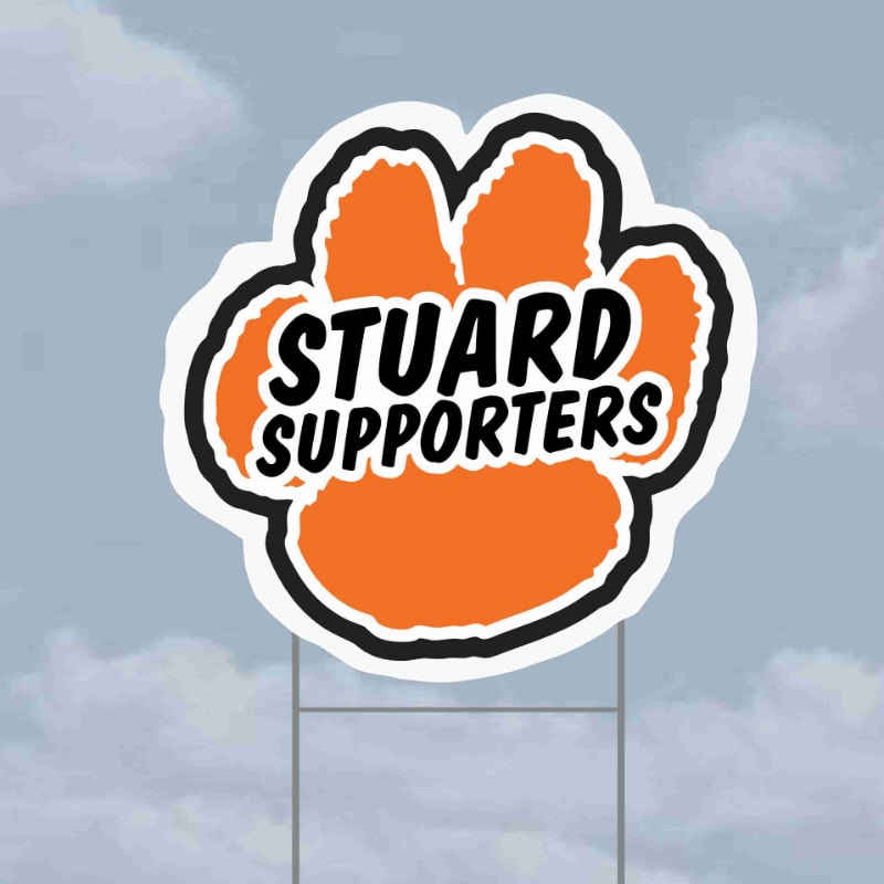 An orange paw print sign with "STUARD SUPPORTERS" written in black letters stands on metal stakes against a cloudy sky.