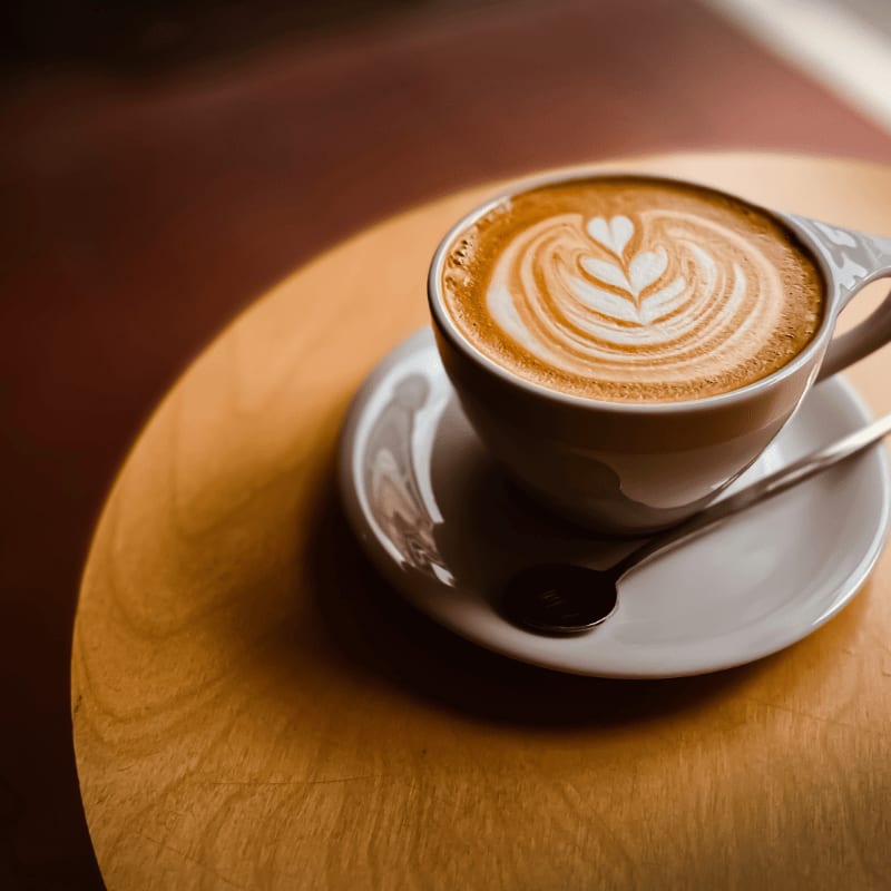 A cup of coffee with latte art on a saucer