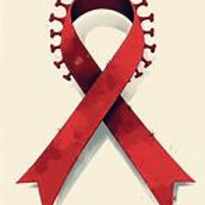 A red ribbon, symbolizing AIDS awareness, is adorned with a crown of virus-like spikes against a plain, light background.