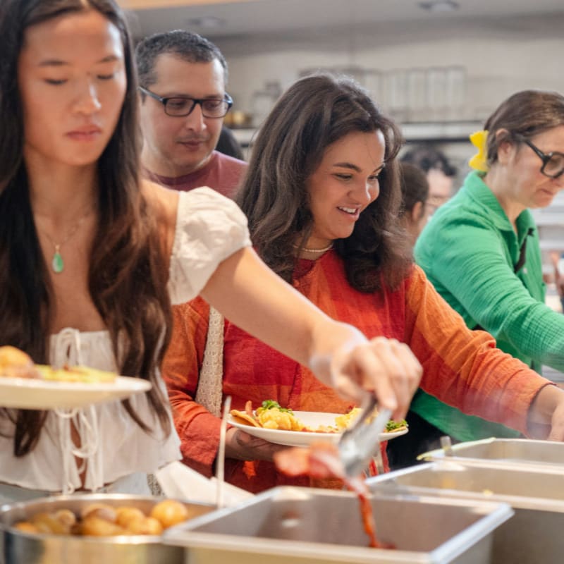 People serving themselves food at a buffet line
