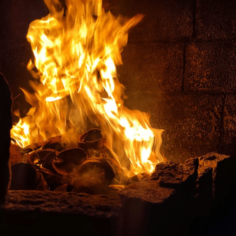 A fire burning inside of a brick fireplace