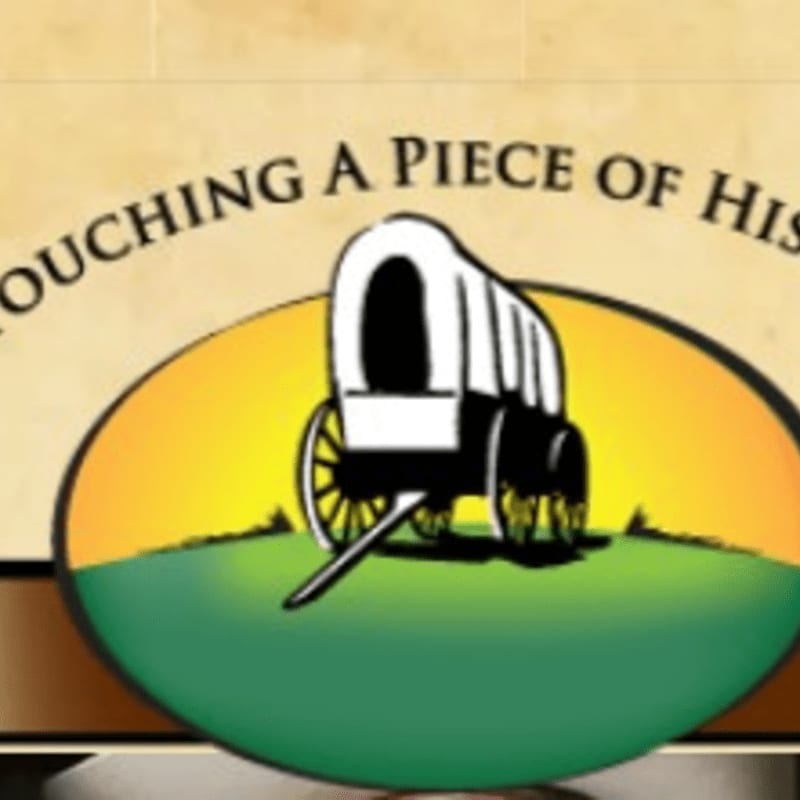 A covered wagon sits on a green hill against a sunset, with the words "TOUCHING A PIECE OF HIS" visible above.