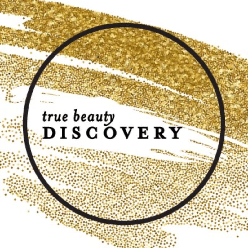A black circle encloses the words "true beauty DISCOVERY" against a background of shimmering gold glitter and white brushstrokes.