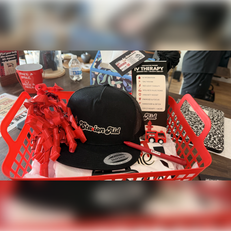 A woven basket filled with grilling tools and Georgia Bulldogs merchandise sits on a dark leather chair.