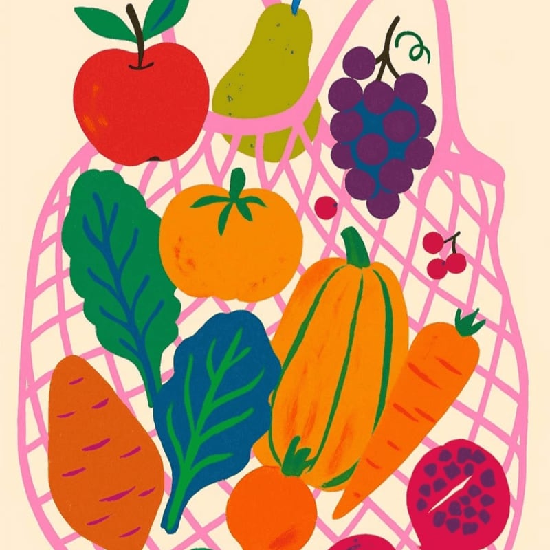 A pink mesh bag overflows with colorful fruits and vegetables, including an apple, pear, grapes, tomato, squash, carrots, and leafy greens, against a pale yellow background.