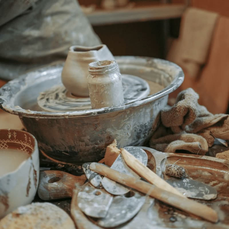 a potter's wheel surrounded by pottery and other items