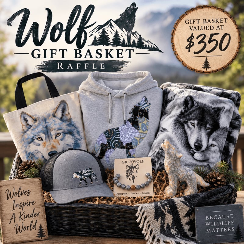 A wolf-themed gift basket filled with apparel and accessories sits on a wooden surface in the foreground, with a mountainous forest landscape in the background.