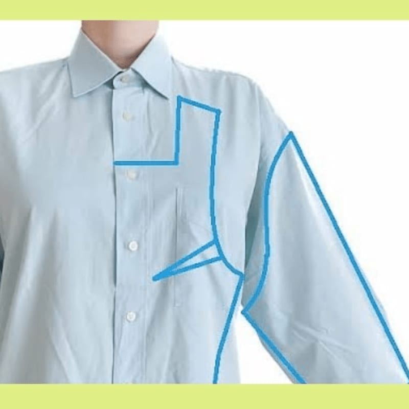 A light blue dress shirt with blue lines indicating alterations is shown against a white background with a green border.