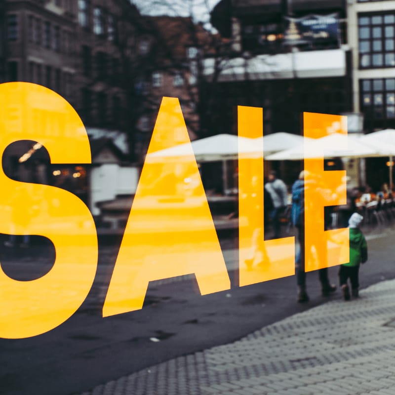 Yellow SALE sign on a shop window overlooking a pedestrian street in Nürnberg