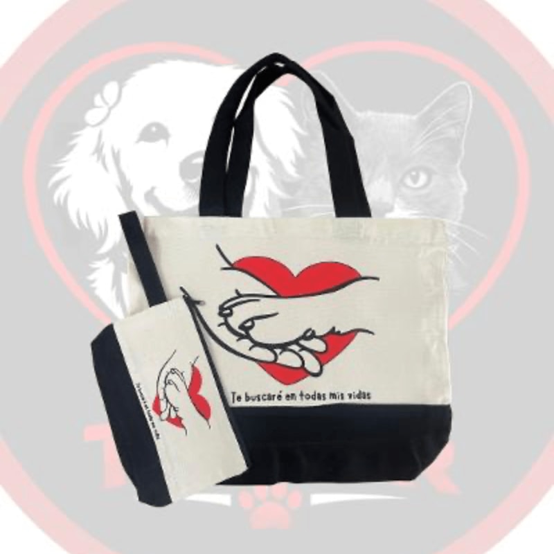 A canvas tote bag and matching pouch with a heart and hand graphic sit in the foreground, while a faint outline of a dog and cat appears in the background.