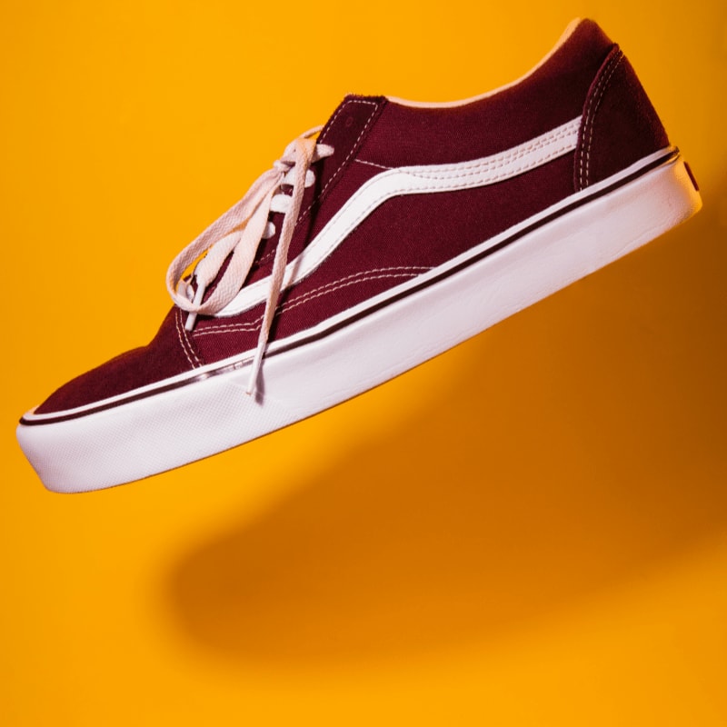 unpaired maroon plimsoll on top of yellow textile