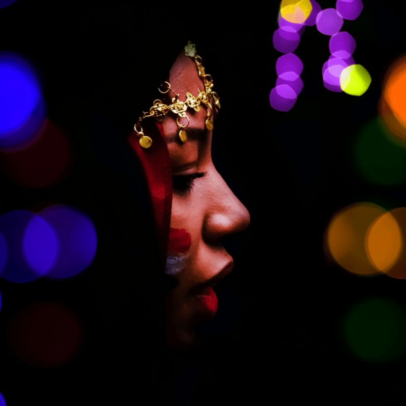 a close up of a woman's face with lights in the background