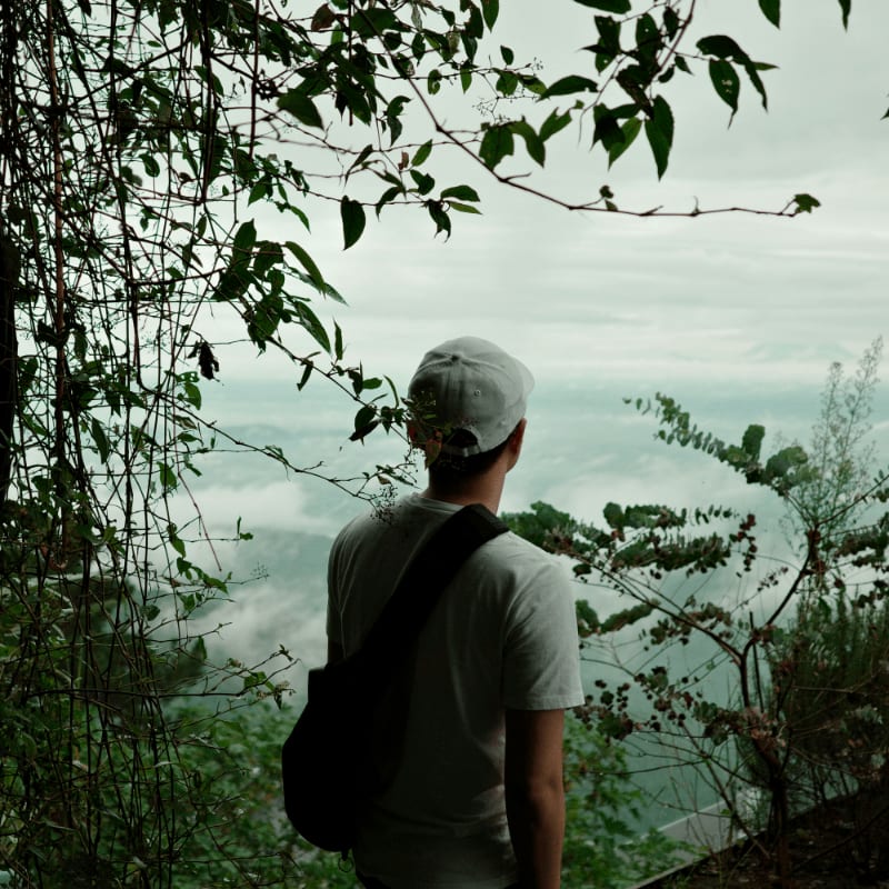 A man with a backpack looking out over the water