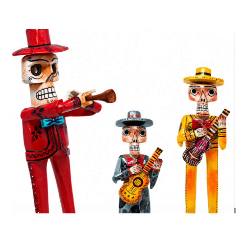 Three colorful skeleton figures dressed as mariachis, playing instruments, stand against a plain white background.