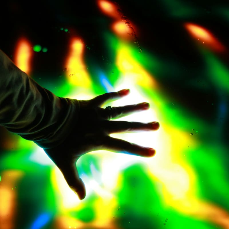 A hand touches colorful lights