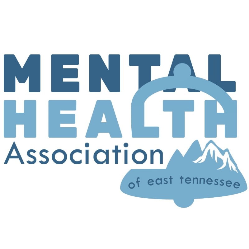 A logo with the words "MENTAL HEALTH Association" in large blue letters in the foreground, and a stylized mountain range with the words "of east tennessee" in the background.