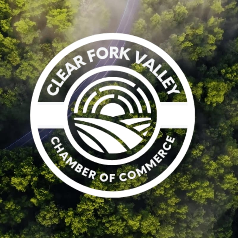 A circular logo for the Clear Fork Valley Chamber of Commerce is superimposed over a lush green forest with a winding road visible in the background.