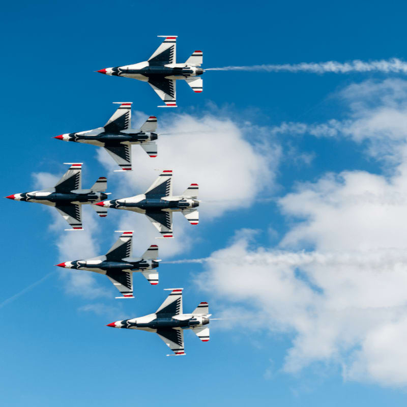 a formation of fighter jets flying through a blue sky