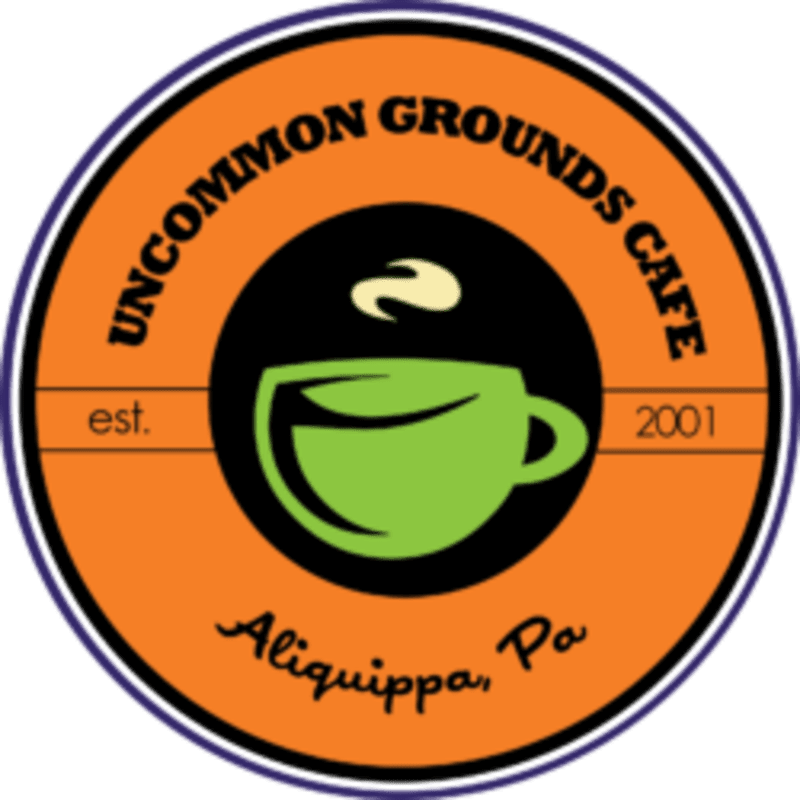 A green coffee cup with steam rising is centered within a black circle, surrounded by an orange circle with text that reads "UNCOMMON GROUNDS CAFE" and "est. 2001 Aliquippa, Pa."