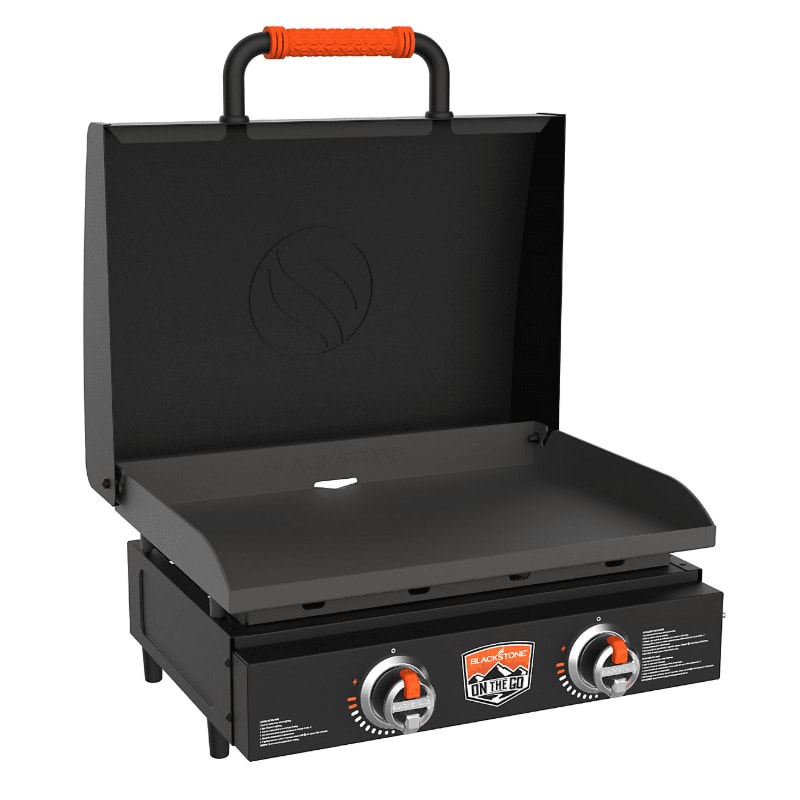 A black portable griddle with an orange handle is in the foreground, with a white background.
