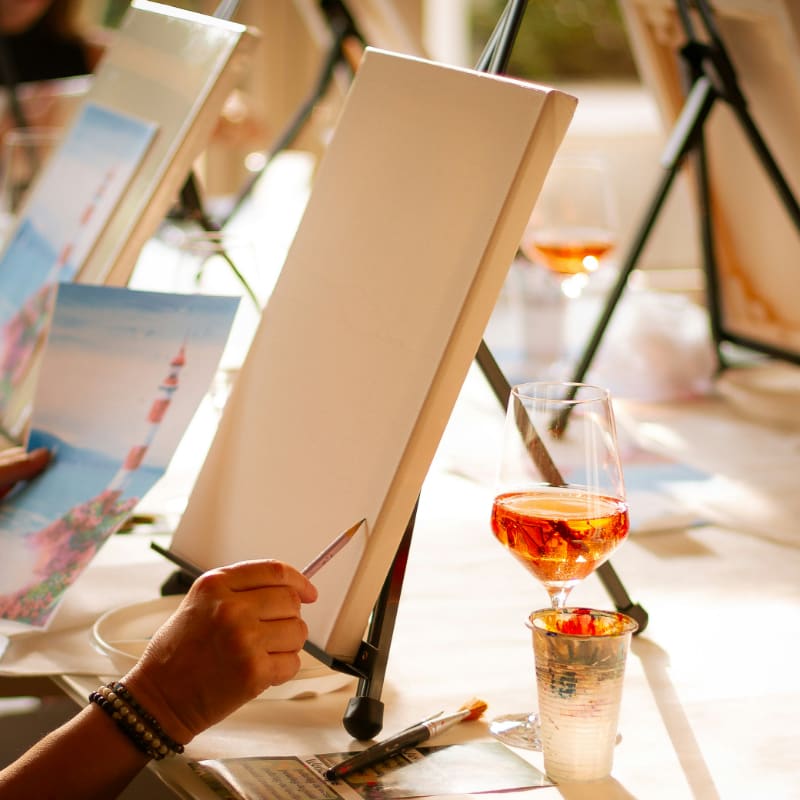 People enjoy painting and drinking wine