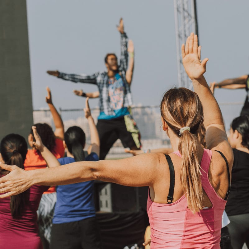 woman in pink tank top raising her hands