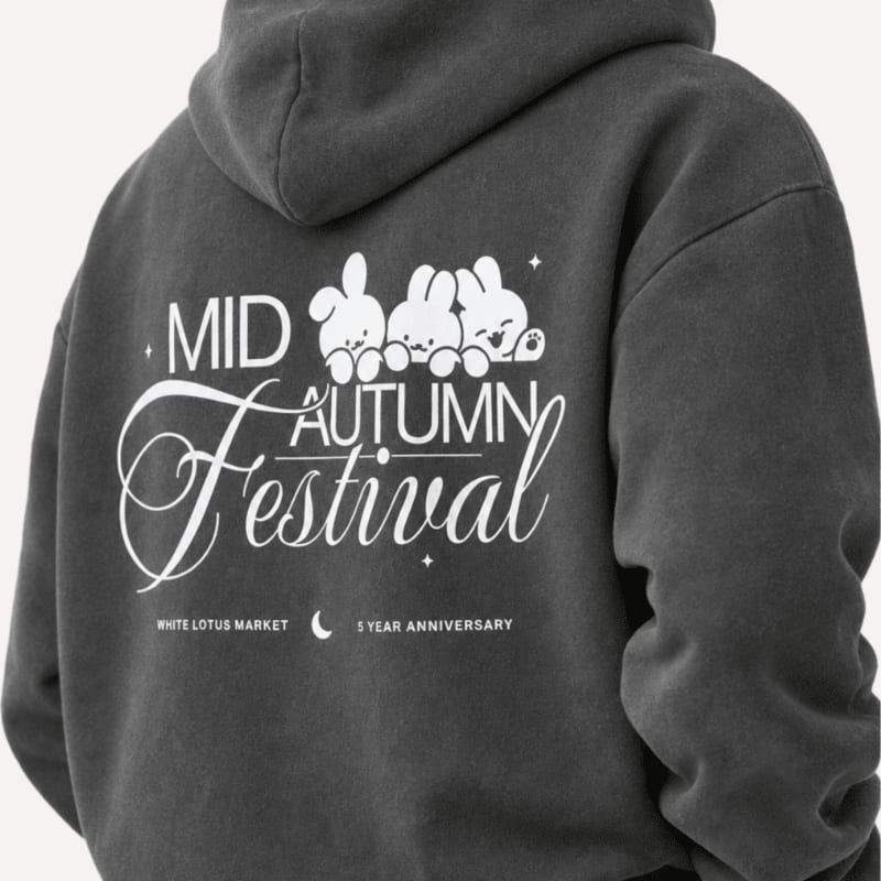 A dark gray hoodie with a "Mid-Autumn Festival" graphic featuring cartoon bunnies is worn by someone, with a plain background.