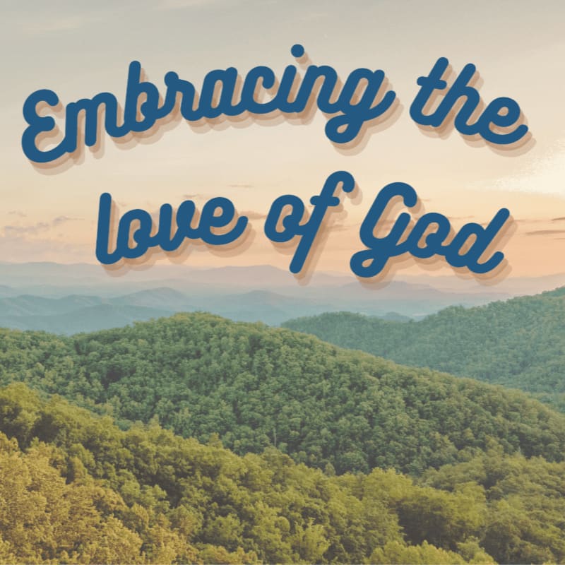 Blue cursive text reading "Embracing the love of God" overlays a scenic background of rolling, forested green mountains under a pale sky.