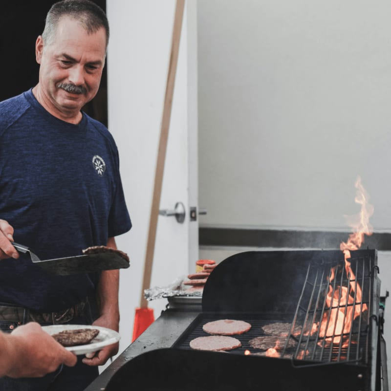 a man is cooking hamburgers on a grill
