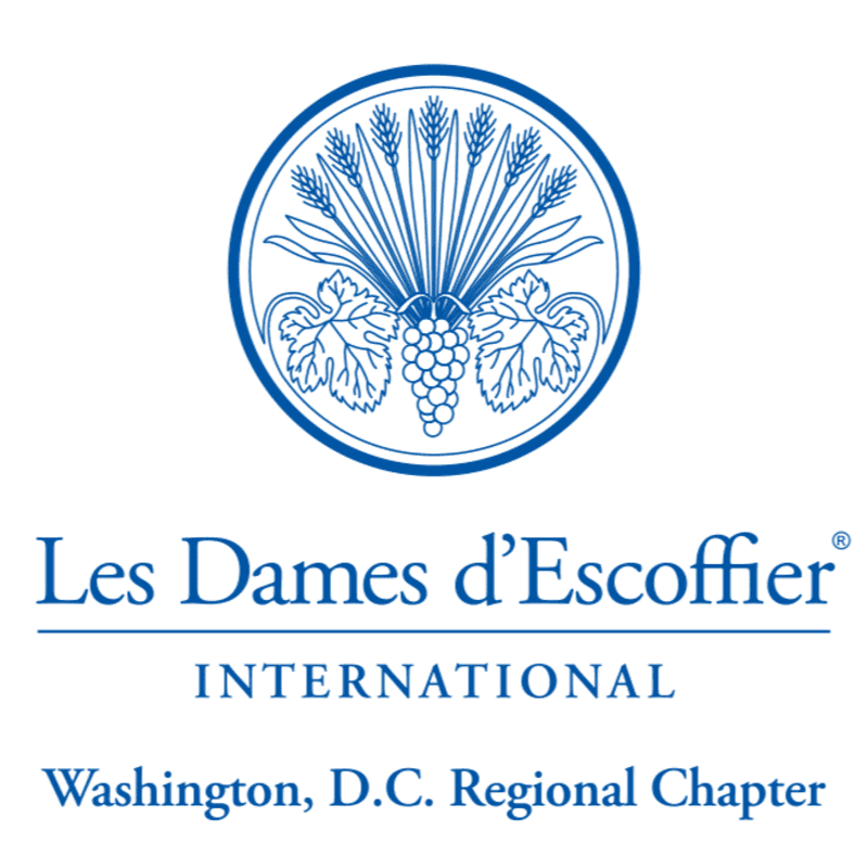 A blue circular emblem featuring wheat stalks and grapes sits above the text "Les Dames d'Escoffier INTERNATIONAL Washington, D.C. Regional Chapter" on a white background.