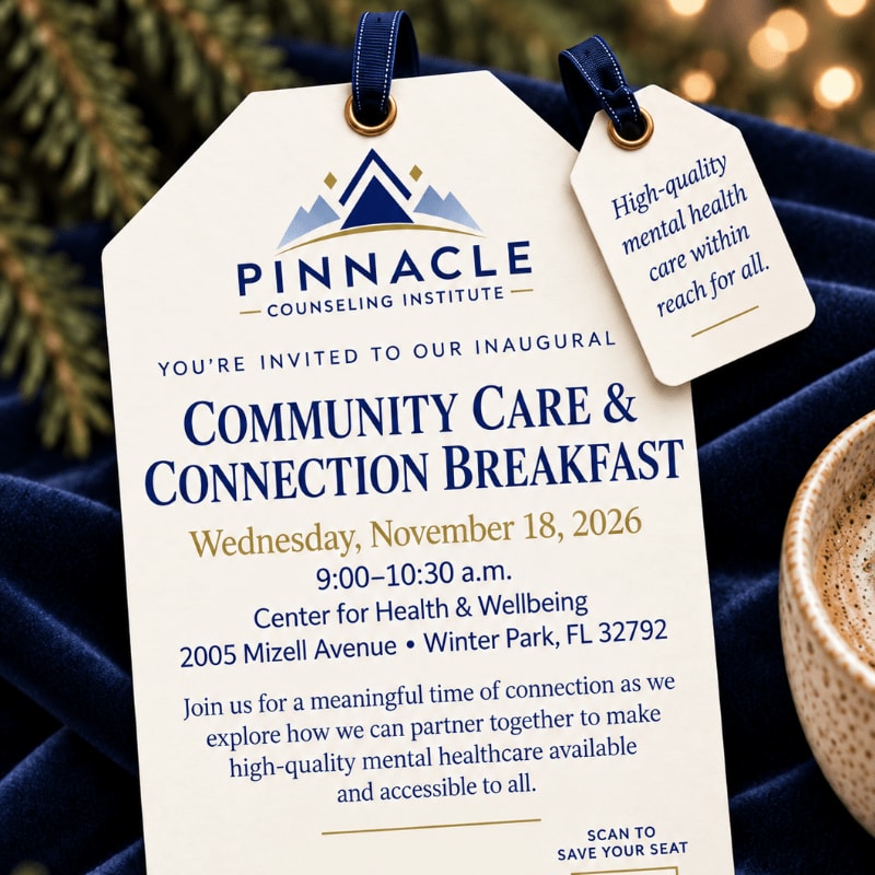 An invitation for the Pinnacle Counseling Institute's Community Care & Connection Breakfast sits atop a navy blue velvet fabric with evergreen branches and soft bokeh lights in the background.