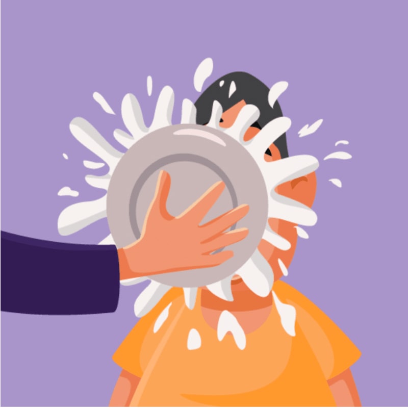 A hand throws a plate of white liquid into a person's face against a plain purple background.
