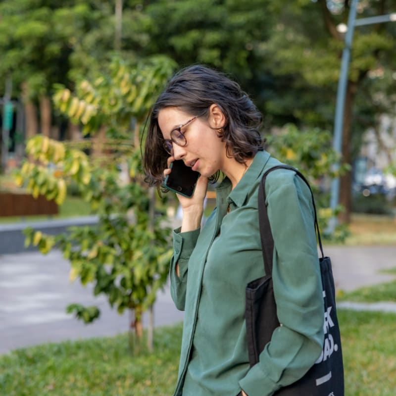 a woman talking on a cell phone in a park