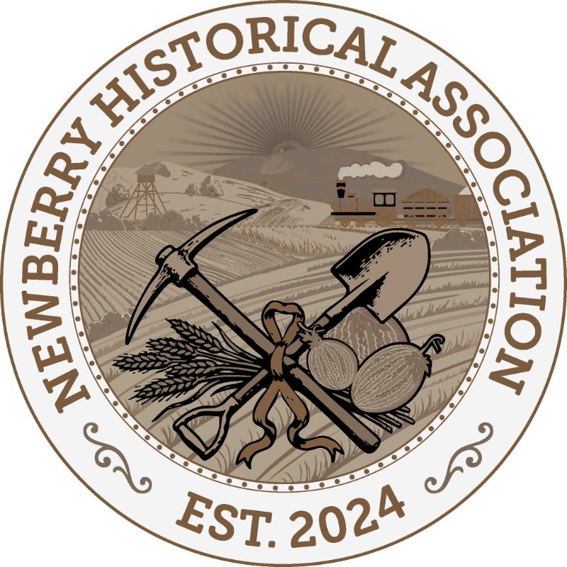 A pickaxe, shovel, wheat, and melons sit in the foreground of a circular logo featuring a rural landscape with a mine headframe and buildings under a rising sun in the background.