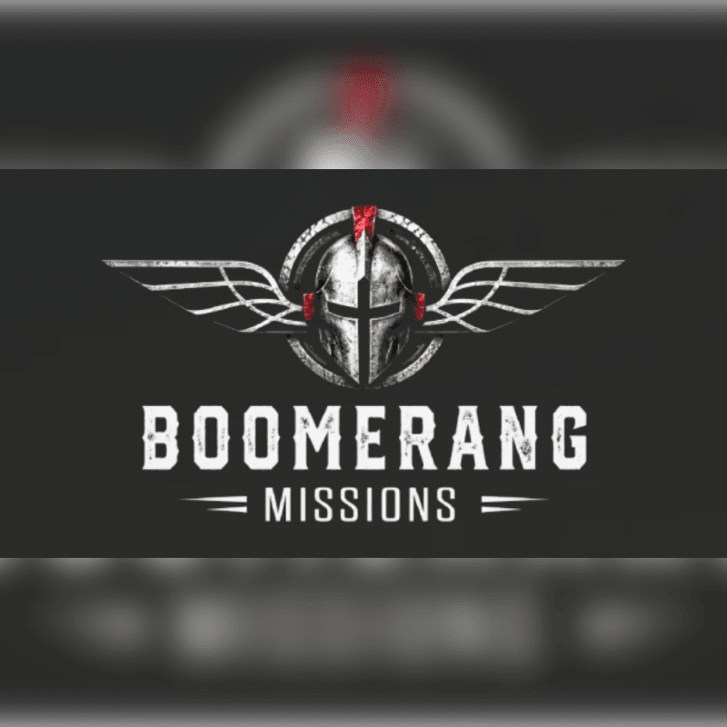 A winged knight's helmet logo with the text "BOOMERANG MISSIONS" is centered against a dark, blurred background.