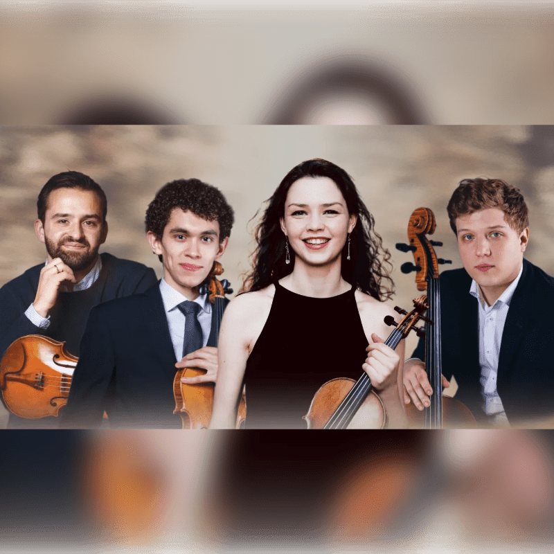 Four musicians holding string instruments pose together against a soft, neutral-toned background.