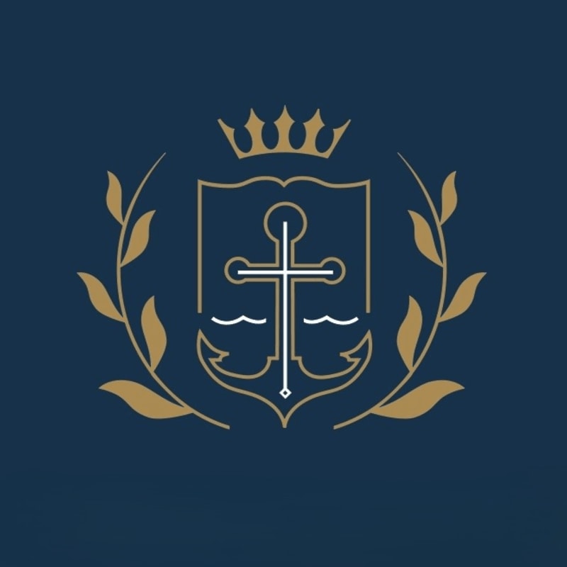 A dark blue emblem featuring a shield with a cross and anchor, topped by a crown and flanked by laurel branches, set against a plain white background.