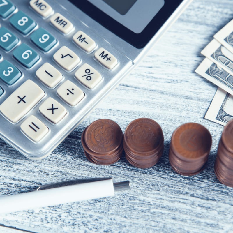 a calculator, pen, and money on a table