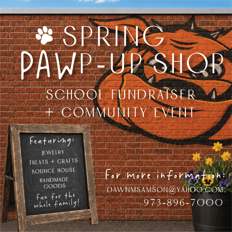 A wooden chalkboard sign and a pot of yellow flowers stand in the foreground against a red brick wall featuring a large orange bulldog graphic and event text.