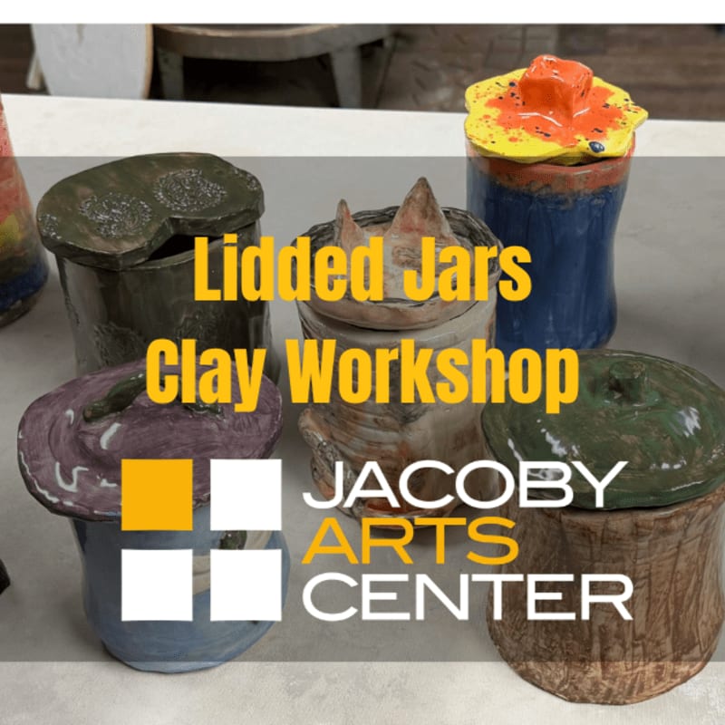 Several colorful, handmade ceramic lidded jars sit on a light-colored surface with a blurred room in the background.
