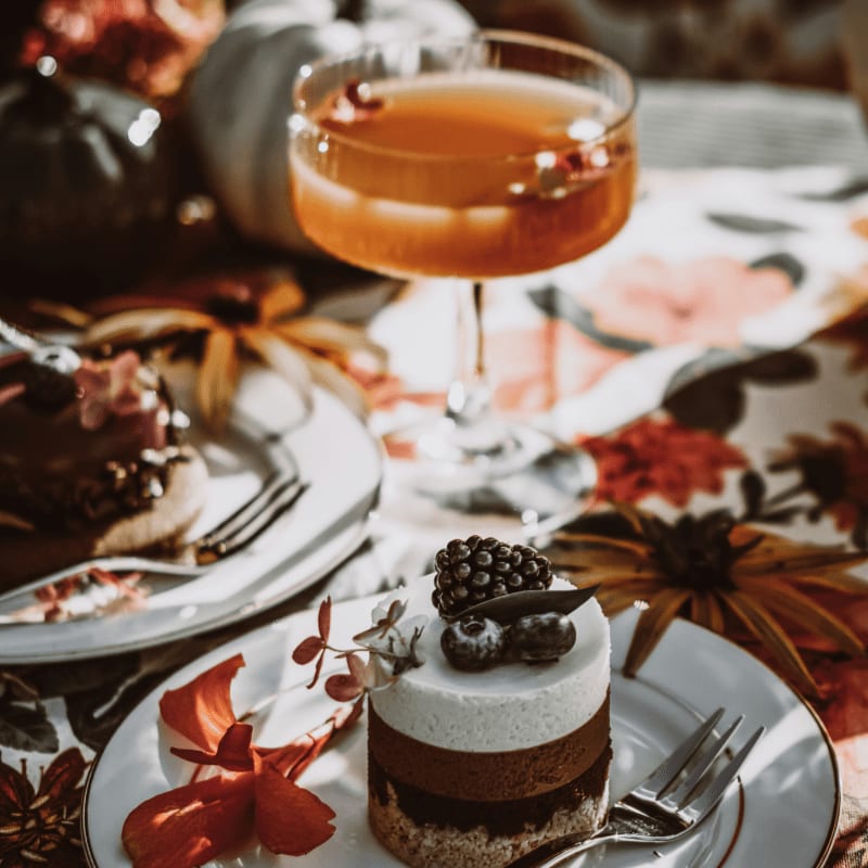 Dessert with berries and a cocktail on a floral tablecloth