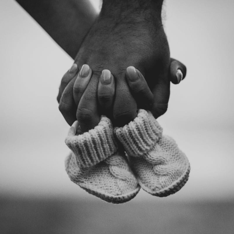 person holding bootees